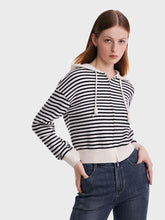 A lady wears a flannel cardigan.